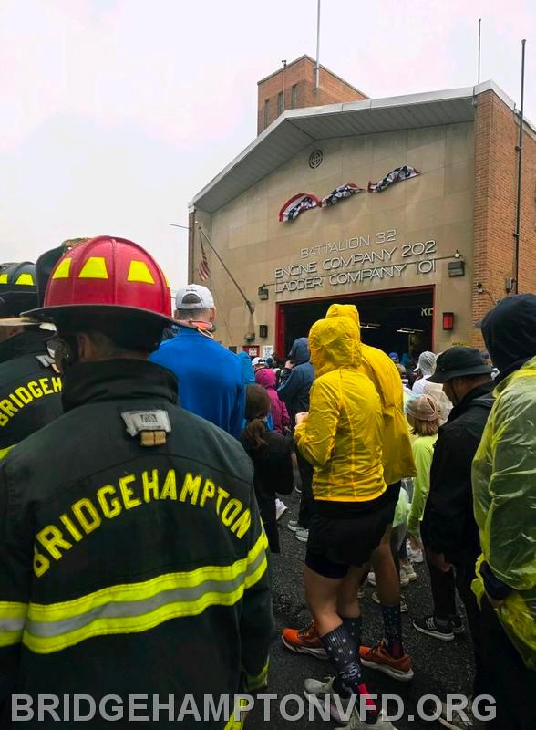 The crowd goes past Battlion 32 Engine Company 202 Ladder Company 101. 